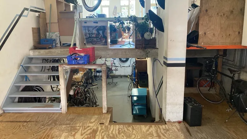 De werkplaats van Fietsjeroen op straatniveau, met fietsen en gereedschap.
